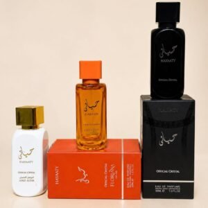 Three luxury perfume bottles in white, orange and black with gold accents, arranged on and next to their respective boxes.
