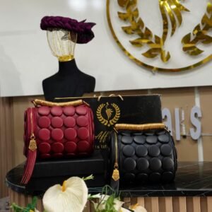 Exquisite red and black handbags with gold accents on display with beautiful flowers